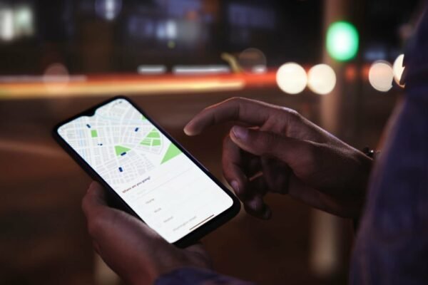 Close-up of man ordering taxi on mobile phone app on the street
